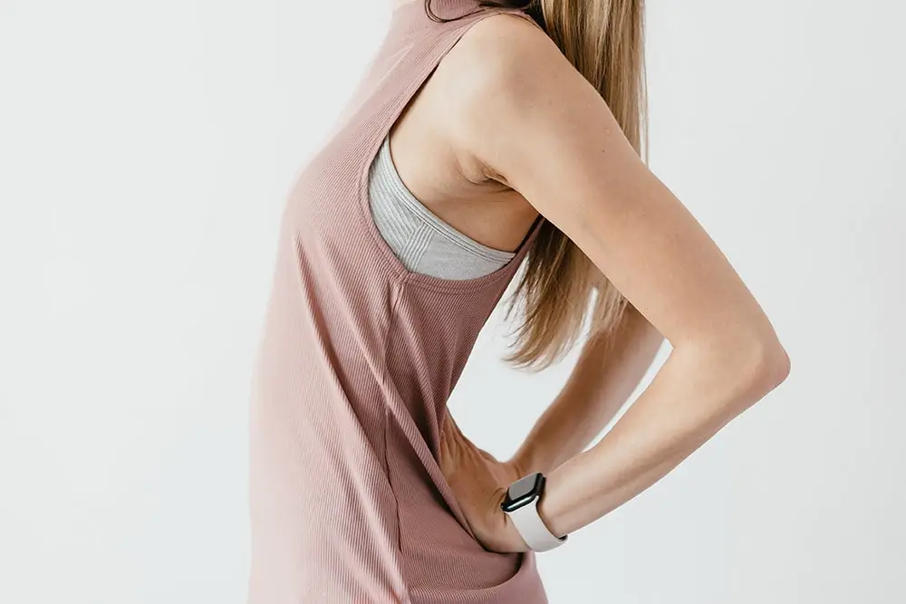 Lady wearing a beige T-shirt. You have a pain in the sacroiliac joint and she keeps her hands in this place
