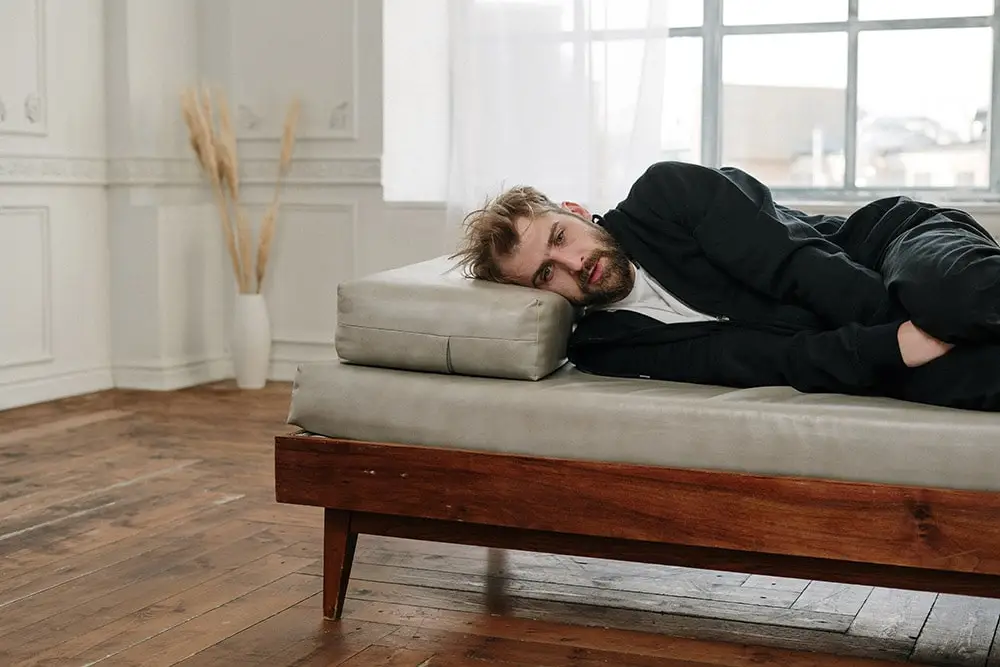 Prostatitis: A man in black clothes with prostatitis is lying on the bed