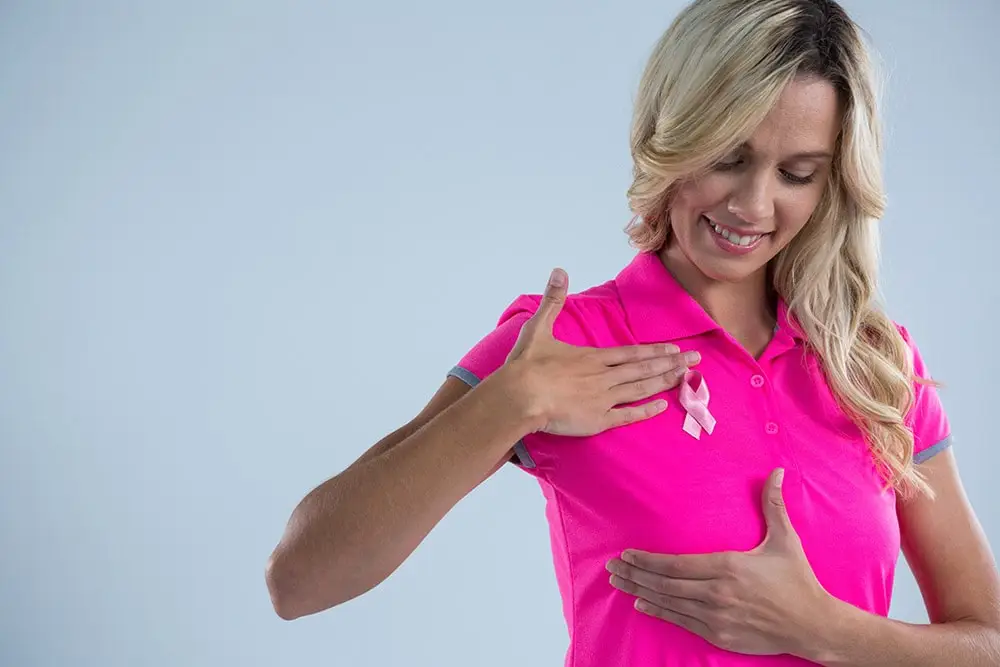 breast cancer, the lady in the pink T-shirt points her hand at her breast