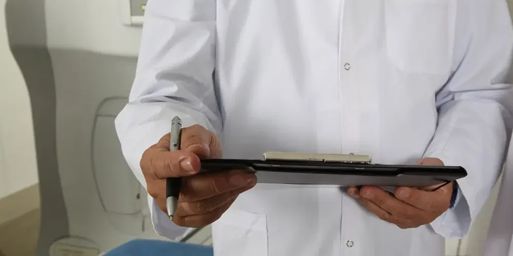 Gallstones: the doctor holds papers and a pen during the visit