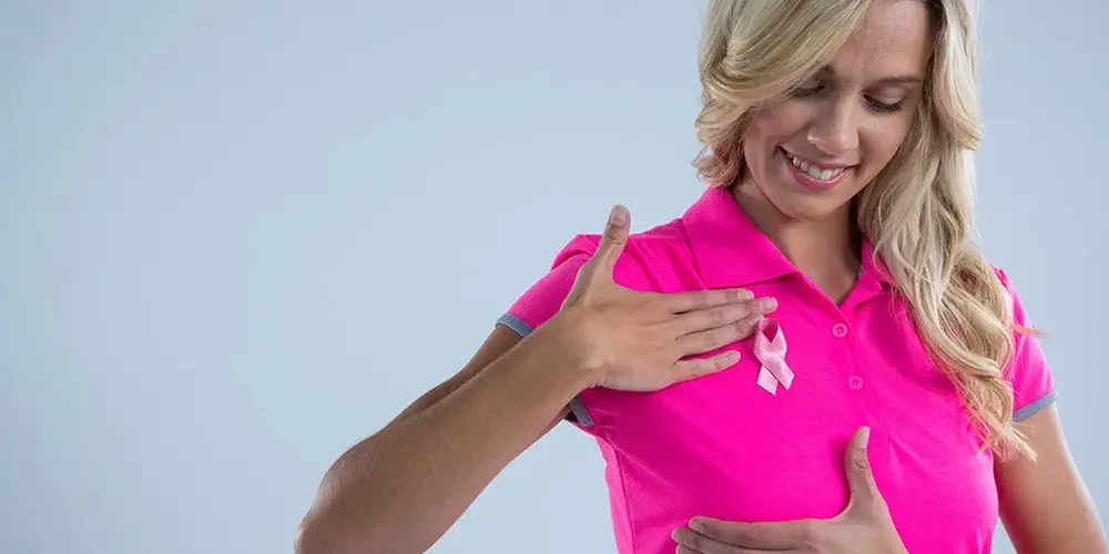 breast cancer, the lady in the pink T-shirt points her hand at her breast