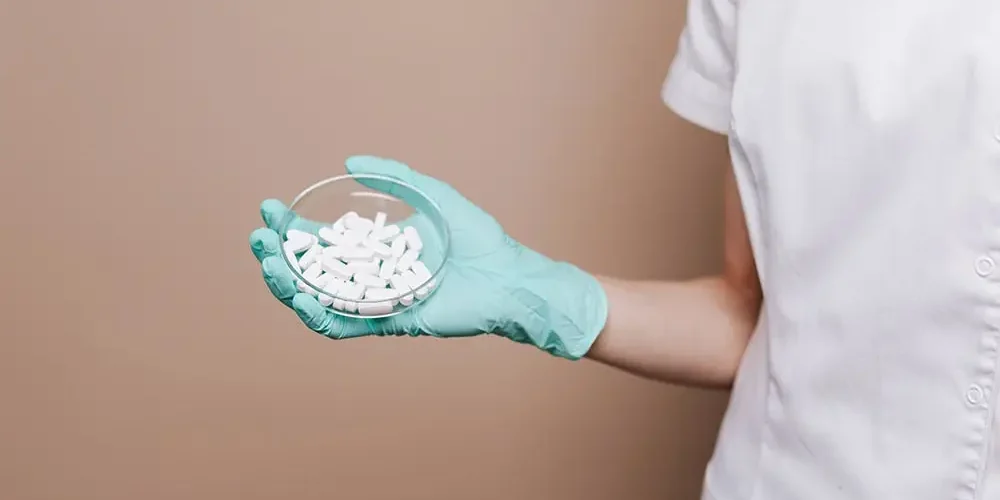 The doctor holds Amantadine tablets in his right hand
