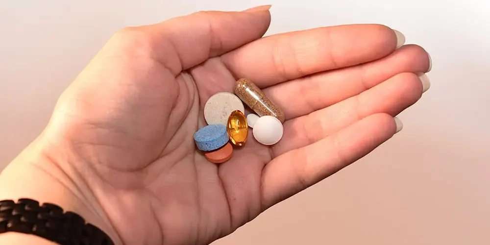 antykoncepcja hormonalna: w ręce są pigułki różnych kolorów