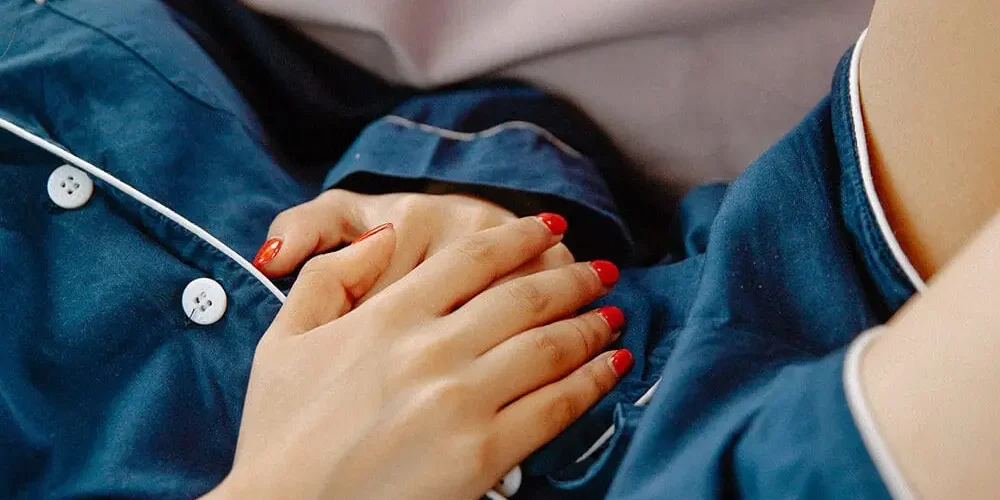 zakażenia układu moczowego: Kobieta trzyma ręce na brzuchu