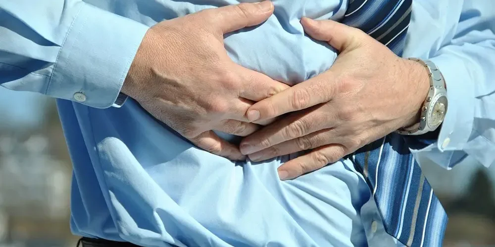 The man in the blue shirt keeps his hand on his stomach because his liver hurts